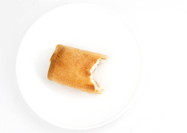 Gehakte pannenkoek met kwark op een wit bord. - Foto, afbeelding