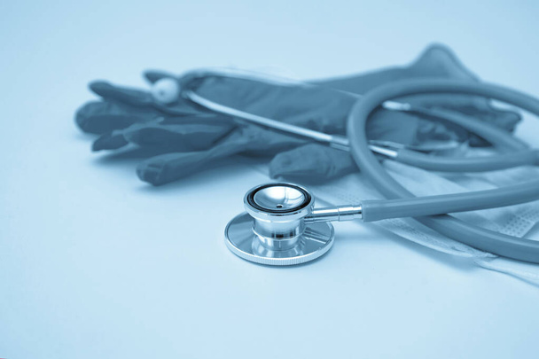 Stethoscope, medical mask and gloves on a light background. Toning. Close up. - Photo, Image