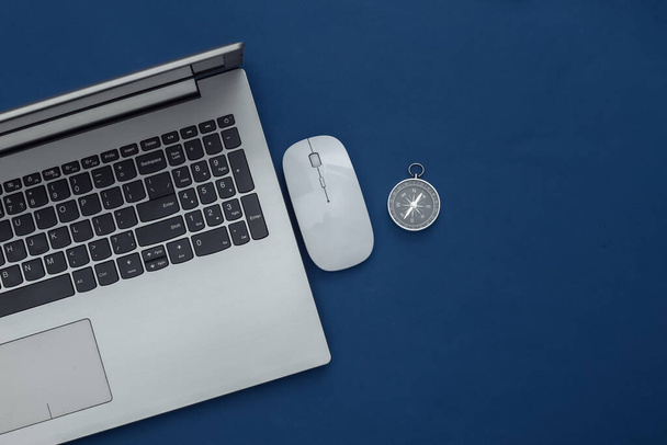 Laptop, PC egér és iránytű klasszikus kék háttérrel. Online üzlet vagy utazás. Felülnézet - Fotó, kép