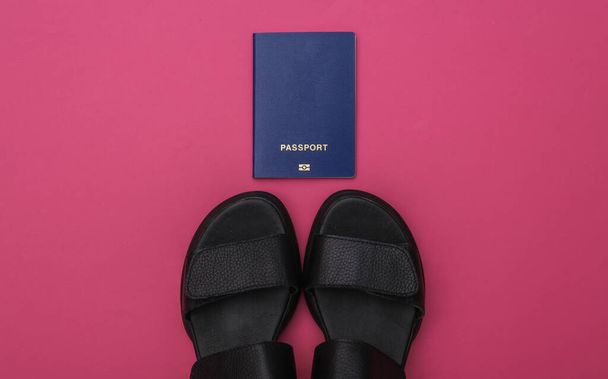 Planification de voyage. Sandales et passeport sur fond rose. Vue du dessus - Photo, image