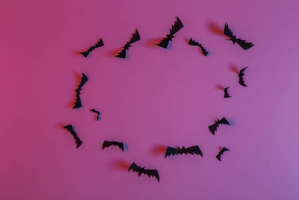 Pipistrelli volanti tagliati di carta in luce al neon blu rosa. Tema di Halloween - Foto, immagini