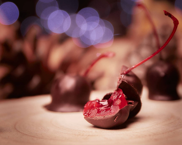 A selective focus shot of chocolate-covered cherries with bokeh background - Foto, imagen