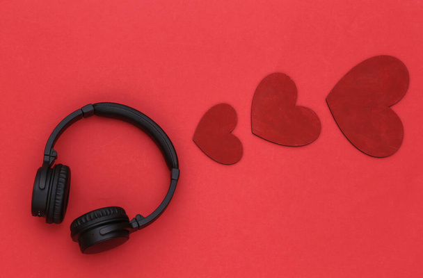 Müzik aşığı. Stereo kulaklıklar ve kırmızı arka planda kalpler. Üst görünüm - Fotoğraf, Görsel