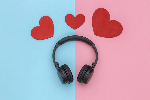 Miłośnik muzyki. Słuchawki stereo i serca na różowym, niebieskim, pastelowym tle. Widok z góry - Zdjęcie, obraz
