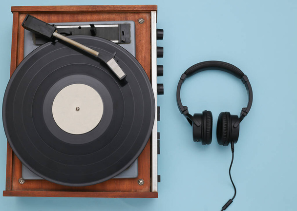 Retro vinyl player and stereo headphones on blue background. Top view. Flat lay - Photo, Image