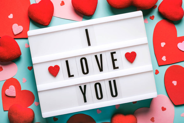 Ευτυχισμένη Ημέρα του Αγίου Βαλεντίνου.Φωτεινό κουτί με τη λέξη "σ 'αγαπώ" και κόκκινες καρδιές σε μπλε φόντο.Valentine ημέρα έννοια - Φωτογραφία, εικόνα