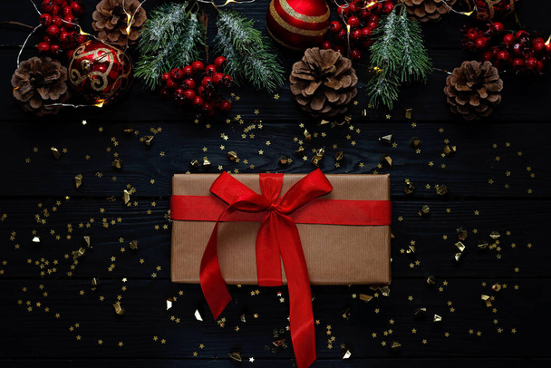 Рождественский черный фон, рождественские шары, ветви и красные ленточки украшения подарки. Новый 2021 год - выборочный фокус. - Фото, изображение