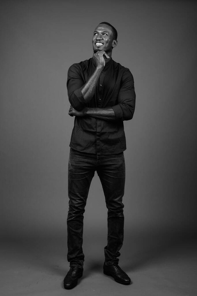 Studio laukaus komea Afrikkalainen liikemies yllään musta paita ruskeaa taustaa vasten - Valokuva, kuva
