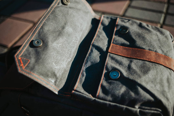 Een hoge hoek shot van een mannen jeans tas op een stoep - Foto, afbeelding