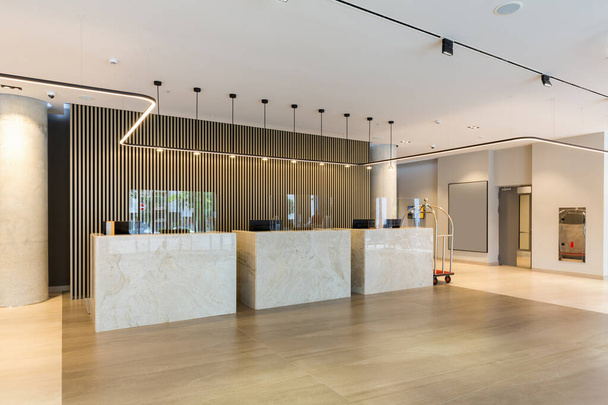 Interior of a hotel lobby with reception desks with transparent coronavirus guards - Foto, Bild