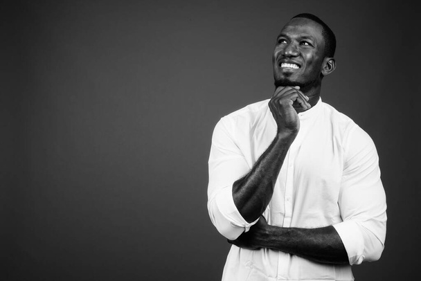 Stúdió lövés jóképű afrikai üzletember visel fehér ing ellen barna háttér - Fotó, kép