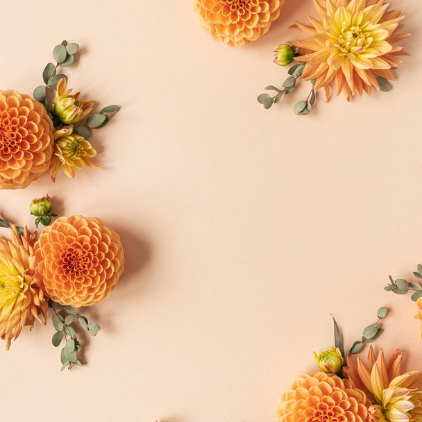 桃のパステルの背景に美しい生姜ダリアの花芽で作られたフレーム。フラットレイアウト、トップビューミニマリズムの花のコンセプト。空のコピースペースモックアップテンプレート. - 写真・画像