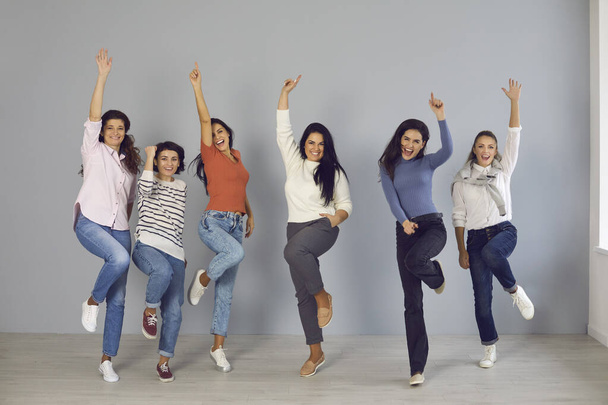 Group of happy young women jumping for joy and laughing, celebrating team success - Фото, изображение