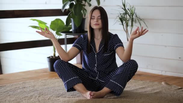 Mladá krásná dívka dělá jógu doma - Záběry, video