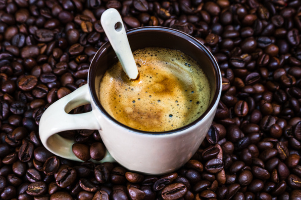 Taza de café con granos de café tostados sobre fondo rojo, concepto de café, foto de café de cerca - Foto, Imagen
