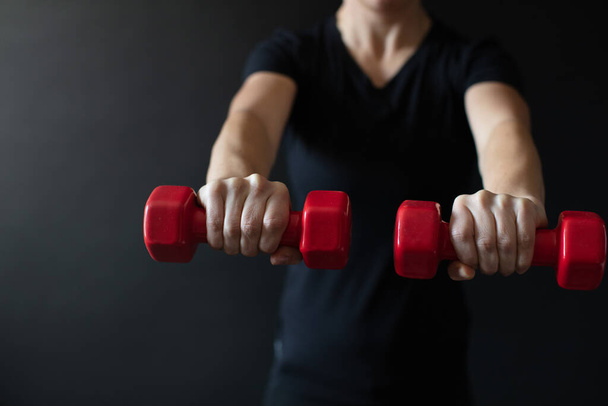 Personal trainer demonstrating dumbbell workout - Foto, Imagen