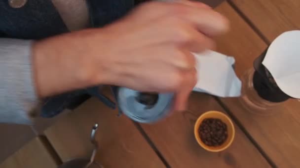 Χειροκίνητη άλεση κόκκων καφέ για την παρασκευή χύνονται πάνω από τον καφέ με μια καράφα V60. Πάνω όψη, κλείστε.. - Πλάνα, βίντεο