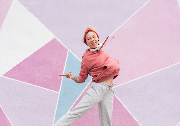 woman jumping in front of a cool pink wall - Photo, Image
