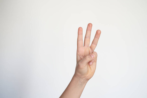 Geïsoleerde kinderhand toont nummer drie. jong handgebaar. - Foto, afbeelding