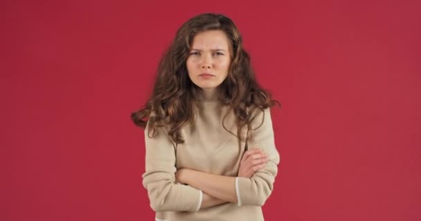 Droevige beledigde vrouw millennial blanke meisje tiener kruist haar armen maakt ontevreden gezicht fronsen wenkbrauwen voelt boze woede misverstand, concept van problemen, studio portret op rode achtergrond - Video