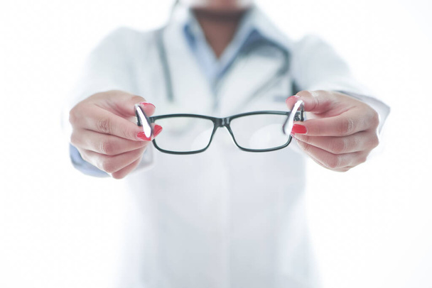 Optometrist holding a pair of glasses - Zdjęcie, obraz