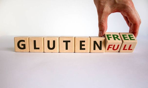 Gluten full or free symbol. Hand turns cubes and changes words 'gluten full' to 'gluten free'. Beautiful white background. Healthy eating and gluten free concept. Copy space. - Zdjęcie, obraz