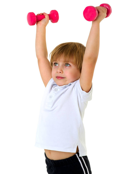 Cute little boy exercising with dumbbells - Фото, изображение