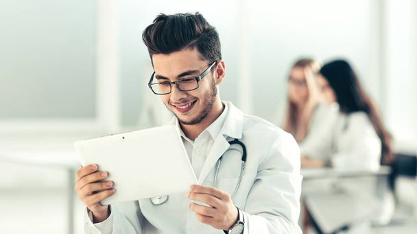 medico sorridente guardando lo schermo del tablet digitale - Foto, immagini