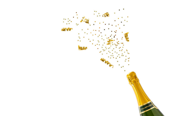 Bottiglia di champagne con coriandoli dorati isolati su fondo bianco. Festeggiamenti di compleanno o Capodanno.  - Foto, immagini