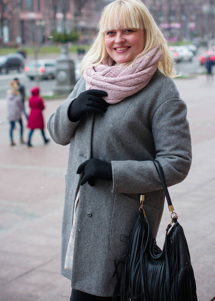 Όμορφη ώριμη γυναίκα σε μια βόλτα στην πόλη. Χειμώνας. Μια ωραία μεσήλικη συν μέγεθος γυναίκα στέκεται στο δρόμο. Τρόπος ζωής των πολιτών - Φωτογραφία, εικόνα