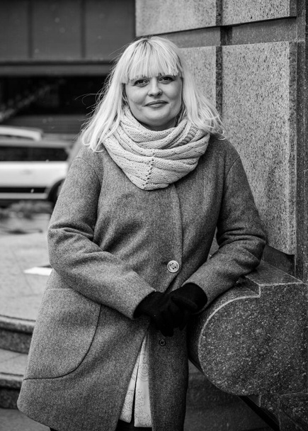 Beautiful mature woman on a walk in the city. Winter time. A nice middle aged plus size woman standing on the street. Citizen lifestyle - Foto, imagen