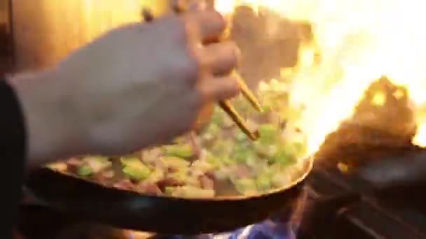 Kuchař vaří smaženou rýži se zeleninou na pánvi - Záběry, video