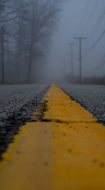 A vertical blurry shot of a road on background of the fog covering the street - Photo, image