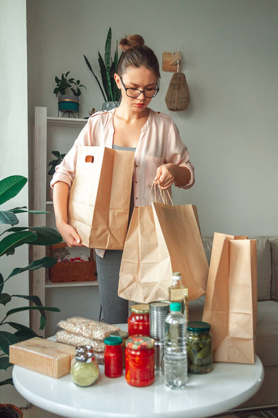 Adományozásra szánt élelmiszert csomagoló nő papírzacskóban, üres másolási hellyel - Fotó, kép