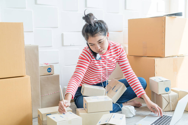 Asian Women business owner working at home with packing box on workplace - online shopping SME entrepreneur or online selling concept - Φωτογραφία, εικόνα