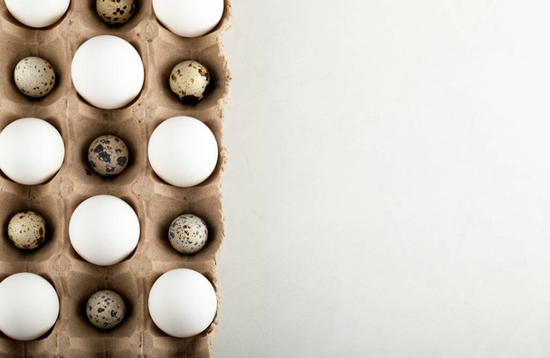 Ovos crus de galinha e codorniz em um recipiente de cartão - Foto, Imagem