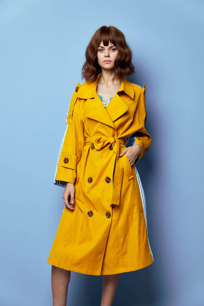 Brunetka, kobieta Patrząc w przyszłość styl życia z krótkimi włosami żółty płaszcz  - Zdjęcie, obraz