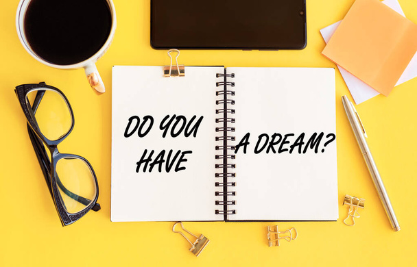 Text Do you have a dream? Written on a notebook with office supplies on a yellow table. Business concept. - Foto, Imagen