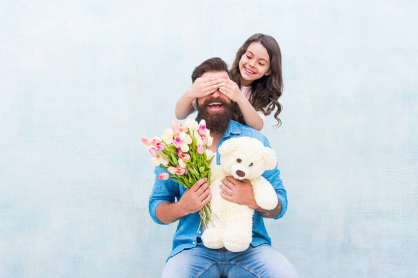girl greeting dad with fathers day. happy family portrait with teddy bear. spring flower bouquet. womens day. prepare tulips for mothers day. daughter and father celebrate birthday. Spring mood - Foto, Imagem