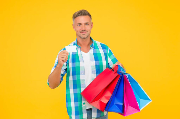 shopaholic. christmas sales and discounts. birthday present packs. guy with credit card. happy man carry shopping bags. black friday. shopper with packages. prepare for holidays. Choosing the best - Foto, afbeelding