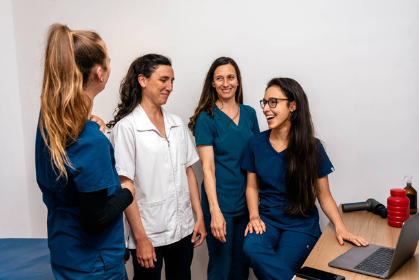 Varastossa kuva yhdistynyt työ ryhmä onnellisia naisia työskentelevät fysioterapia klinikalla. - Valokuva, kuva