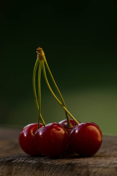 deliciosas cerejas frescas no fundo de madeira e fundo natural na vertical - Foto, Imagem