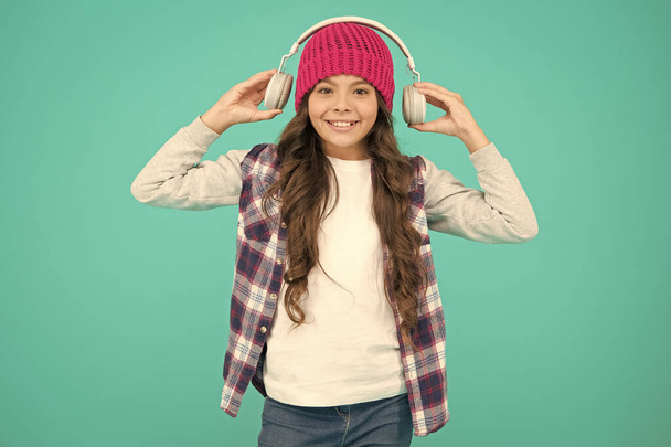 too loud. teenager listen music in headset. audio book for little kid. self education online. small child long hair enjoy sound. happy childhood. happy hipster girl turquoise background - Fotoğraf, Görsel