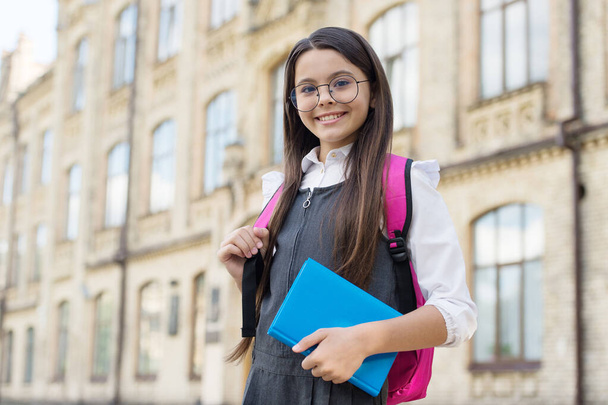 Learn well today. Happy kid in glasses carry book and backpack. Back to school essentials. School library. Knowledge day. Formal style. Fashion uniform. Primary education. Startup. September 1 - Fotoğraf, Görsel