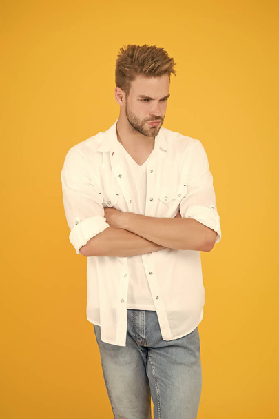 fashion and people concept. Sexy and handsome. Confident young handsome man in jeans shirt. guy wearing jeans and t-shirt. man in white shirt. Muscular man in jeans yellow background. Young and free - Fotografie, Obrázek
