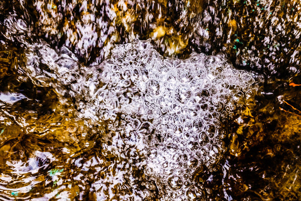 Wasserblasen in einem Strom aus reinem kristallinem Wasser vor seiner Kontamination. - Foto, Bild