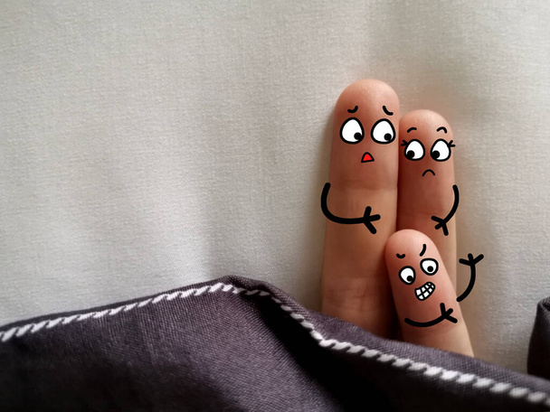 Tři prsty jsou vyzdobeny jako rodiče a malé dítě. Rodiče se ptají, jestli jejich dítě má  - Fotografie, Obrázek