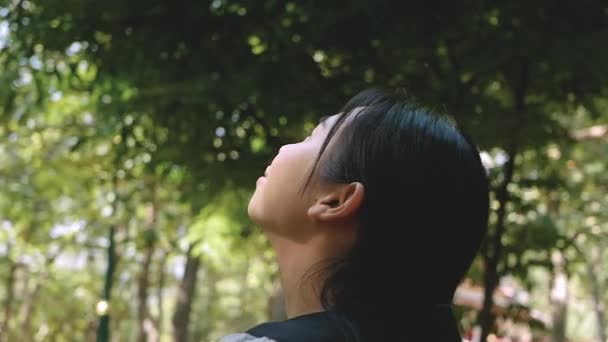 Asian young woman enjoying with nature in the park on sunshine day. - Felvétel, videó