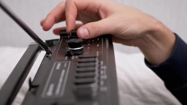Muž nastaví frekvenci starého přijímače otáčením otočného knoflíku s prsty - Záběry, video
