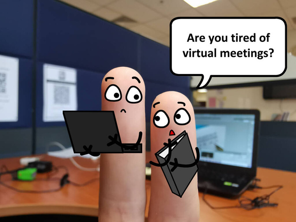 Δύο δάχτυλα είναι διακοσμημένα ως δύο άτομα στο γραφείο. Ο ένας ρωτάει τον άλλο αν βαρέθηκε τις εικονικές συναντήσεις.. - Φωτογραφία, εικόνα